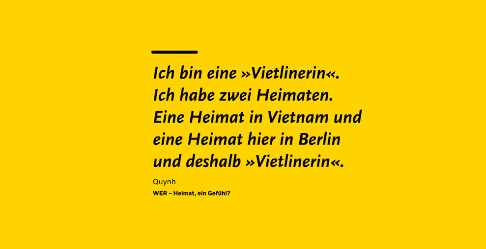 Auf gelbem Hintergrund steht in schwarz: Ich bin eine "Vietlinerin". Ich habe zwei Heimaten. Eine Heimat in Vietnam und eine Heimat hier in Berlin und deshalb "Vietlinerin". Zitat von Quynh aus "WER? - Heimat, ein Gefühl"